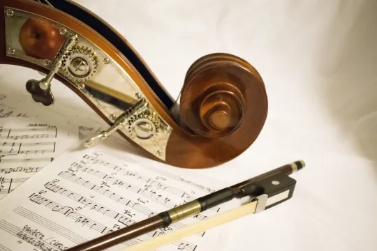 een viool met een muziekboek en een pen
