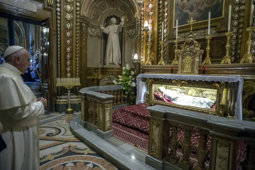 This handout photo taken on June 21, 2015 and released by the Vatican press office, Osservatore Romano shows Pope Francis praying s in front of the casket containing the body of Don Giovanni Melchiorre Bosco inside the Santa Maria Ausiliatrice Church in Turin, as part of his two-day visit in Turin as part of his first pastoral trip to northern Italy. AFP PHOTO / OSSERVATORE ROMANO