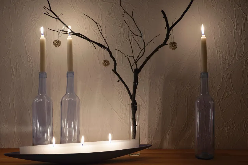 Kaarsen in wijnflessen op een tafel