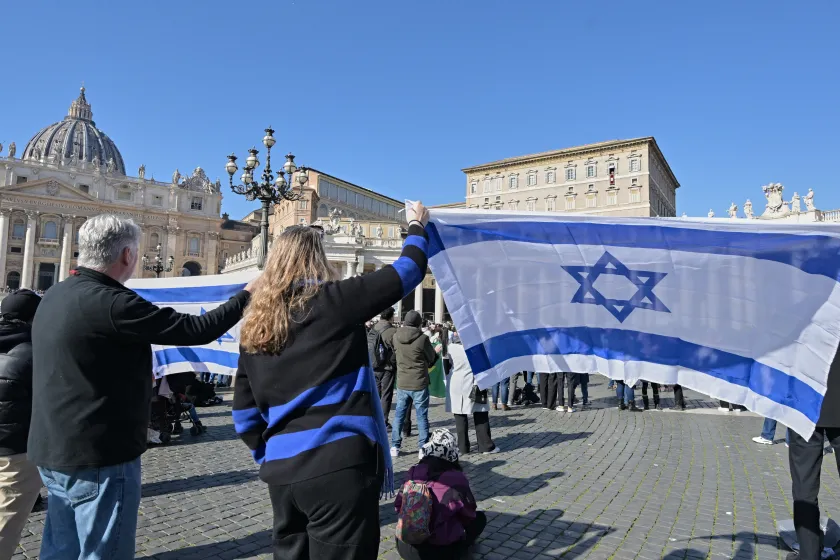 German activists hold Israeli flags as Pope Francis waves to the crowd from the window of the Apostolic Palace overlooking St. Peter's Square in the Vatican, during the weekly Angelus prayer, on February 4, 2024. Andreas SOLARO / AFP