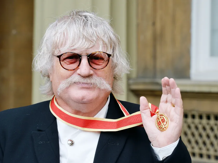 Karl Jenkins poses with his Insignia of Knighthhood after being appointed a Knights Bachelor for services to composing and crossing musical genres at an investiture ceremony at Buckingham Palace on October 6, 2015. AFP PHOTO / POOL / JOHN STILLWELL